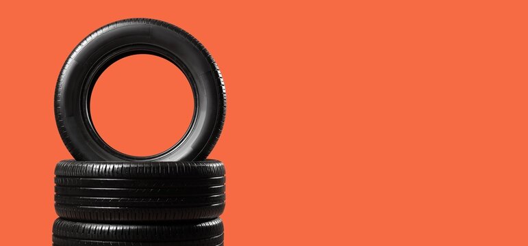 Car tires on orange background with space for text