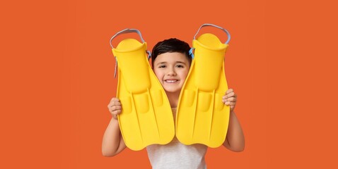 Cute little boy with yellow flippers on orange background © Pixel-Shot