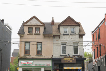 Naklejka premium historic houses and exterior building facade with signs of Krispy Kreme Café and Jimmy's Coffee (164-166 McCaul St), Toronto