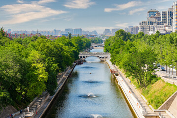 Fototapeta premium Scenic view of the ancient city wall moat and green park contrasted with modern residential skyscrapers in Xi'an, Shaanxi, China