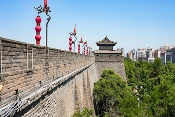 Perspective view of the ancient massive stone wall and watchtower adorned with red lanterns in Xi'an, Shaanxi, China © Alexandre ROSA