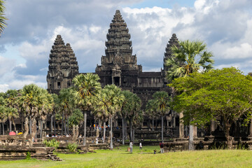 Fototapeta premium Angkor Wat, Siem Reap, Cambodia. Tourists explore the ancient temple complex, a UNESCO World Heritage site, on a cloudy day.