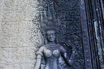 Fototapeta premium Apsara dancer carving on the ancient temple walls of Angkor Wat, Siem Reap, Cambodia. These celestial dancers are a common motif in Khmer art.