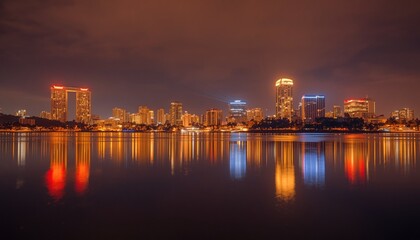 Fototapeta premium An urban landscape at dusk, with buildings illuminated in neon lights reflecting on the waters of a tranquil lake, creating a contrast between the city and nature.
