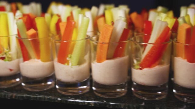 Vegan vegetarian snacks on decorated catering banquet table, with different salads, vegetable, cucumbers, pepper, carrot and celery sticks on corporate birthday party event or wedding reception 