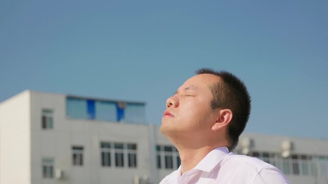Asian man pours water over his head to cool down in the scorching summer heat.