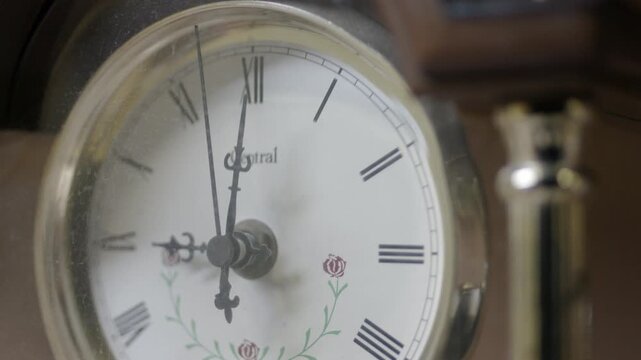 Close up angled shot of vintage antique mantel clock ticking time