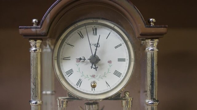 Close up of vintage antique mantel clock with roman numerals ticking time