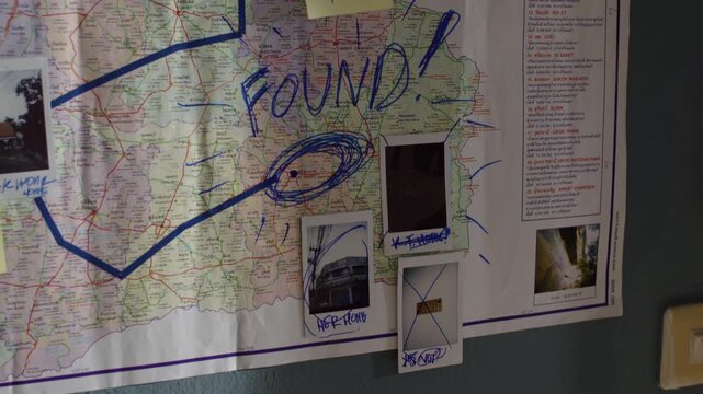 Criminal tracking wall map of northeastern Thailand with mystery notes and case evidence.