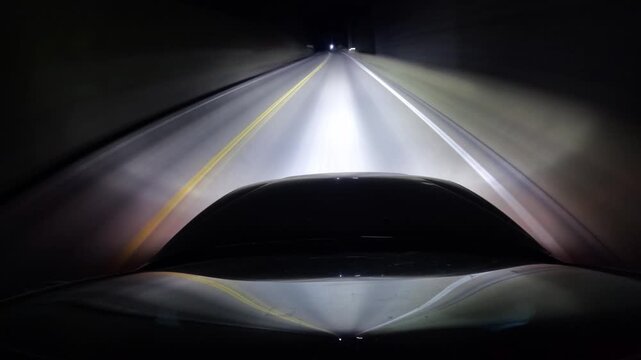 Vehicle's headlights pierce nighttime darkness