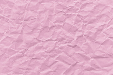 Fototapeta premium Crumpled pink paper texture with visible creases and folds.