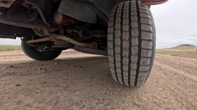Vehicle tire close-up on rough dirt surface