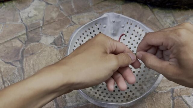 Hand picks fresh herbs from a metal colander