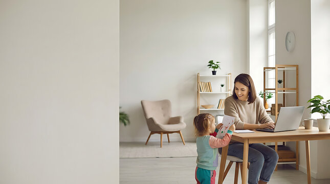 Mother working on laptop while her daughter shows her a drawing