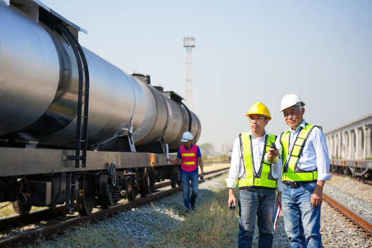 Engineers inspecting freight tank cars at railway depot, Team of industrial worker and engineer conducting train safety inspection, Railway transport inspection with experts at freight train terminal