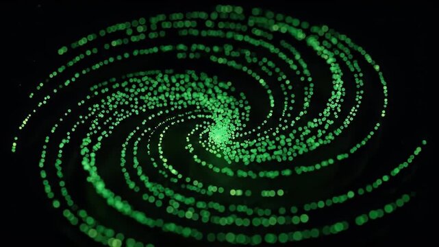Green glowing particles swirling in spiral pattern against black background