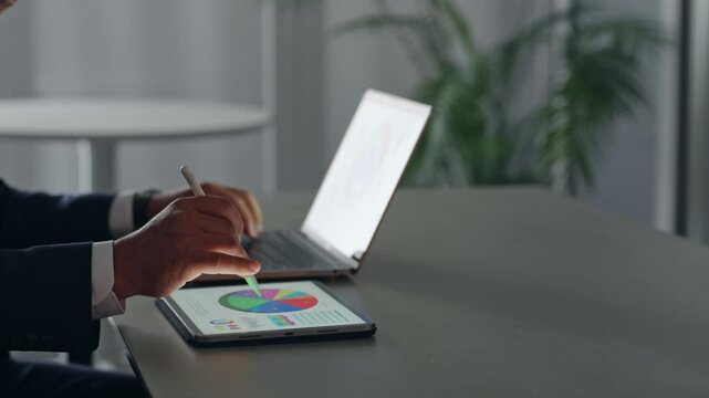 ノートパソコンとタブレットPCを使って作業する男性ビジネスパーソン