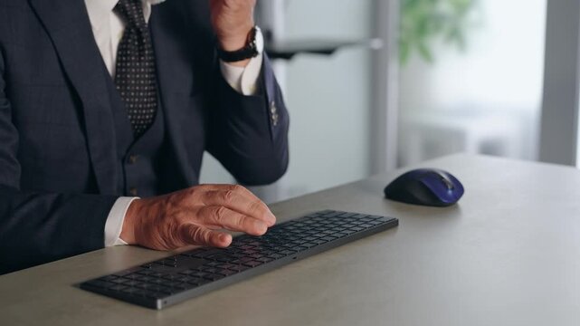 A male business person operating a PC keyboard.