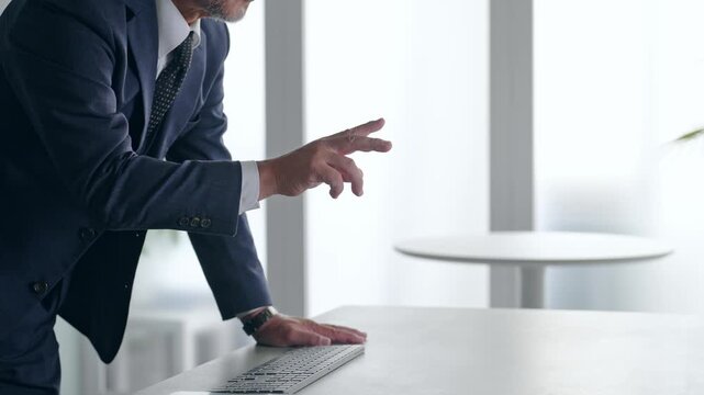 A male businessperson operating a screen in mid-air.