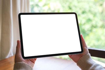 Mockup image of a woman holding digital tablet with blank white desktop screen at home © Farknot Architect