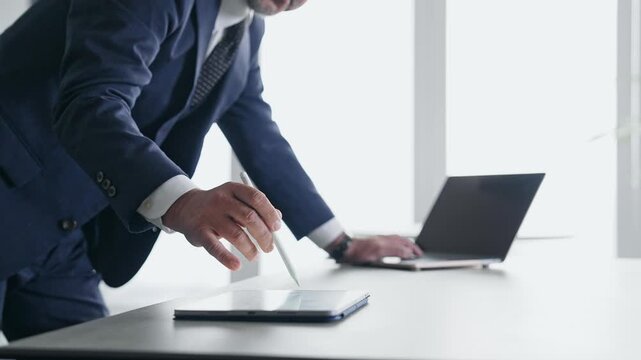 A man working using a laptop and a tablet PC.