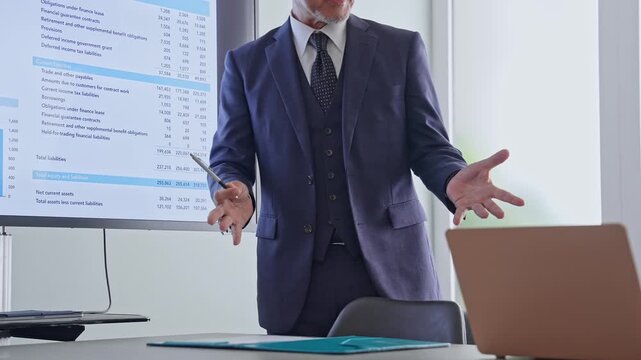 A group of business people holding a meeting while looking at a screen.