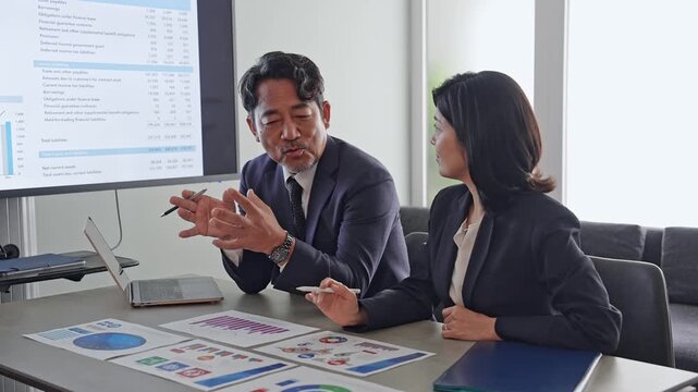 書類を見ながら会話するビジネスパーソンのグループ