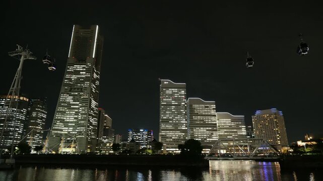横浜みなとみらいの高層ビル群のライトアップと水辺の反射　都市夜景