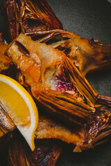 Extreme macro shot of cooked artichoke hearts with savory seasoning and citrus garnish. Gourmet restaurant menu and premium food photography concept, vertical close up view. © 5ph