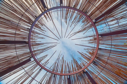 Abstract circular garden sculpture viewed against blue sky in Adelaide Botanic Garden