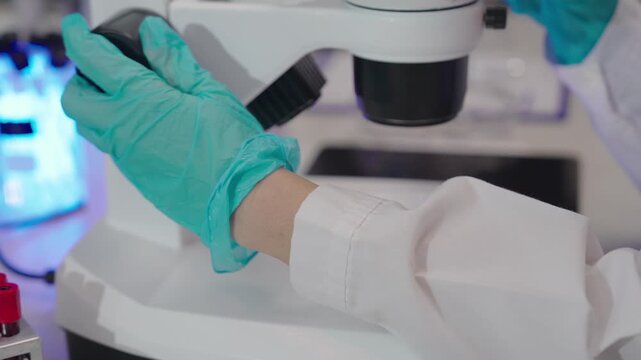 Young researchers are analyzing samples and taking notes in the science lab. A team of lab technicians is working with microscopes and recording research data.