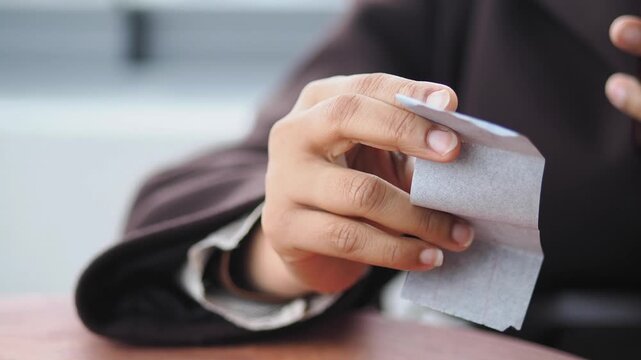 A person is holding a piece of sales receipt