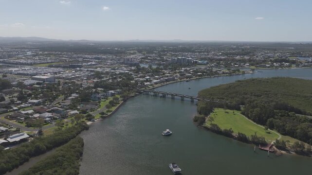 Road Bridge Across Coombabah Creek Connecting Jabiru Island And Suburban Landscape In Queensland. aerial pullback shot