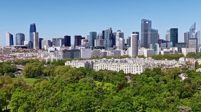 Bois de Boulogne with modern skyscrapers of La D&eacute;fense business district in background in Paris, France. Aerial drone lateral view
