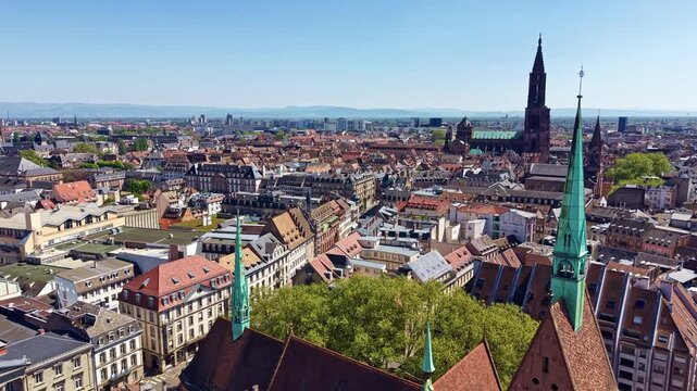 Drone view showing Saint-Pierre-le-Jeune Protestant Church in foreground and Cathedral of Notre Dame in background in Strasbourg, France. Aerial forward
