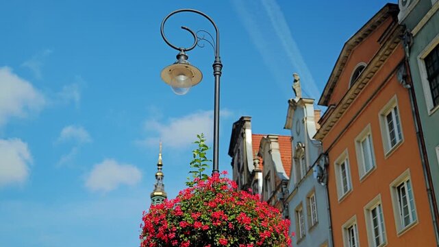 Sunny Old Town atmosphere with decorative streetlamp and church tower in Poland