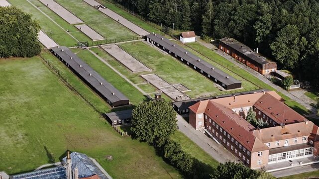 Drone reveals organized camp barracks and confinement layout beside forest