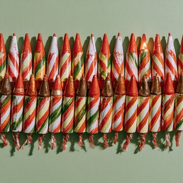 Row of striped bottle rocket fireworks arranged on a plain background for patriotic holiday social media, party invitation design and seasonal firework advertising