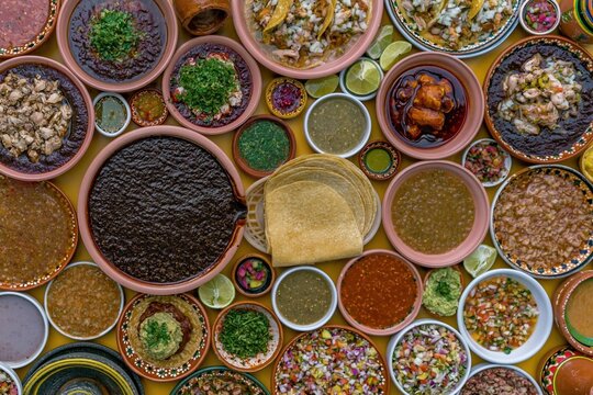 Mexican mole poblano and traditional dishes arranged on a yellow surface for festive dining, heritage celebrations and restaurant menu marketing