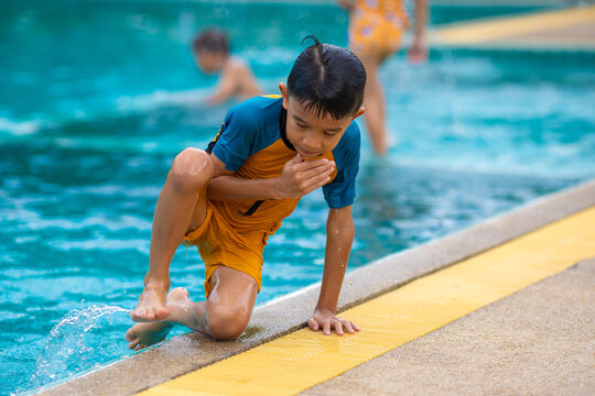 Adorable asian school kids boy and girl enjoy swim practice