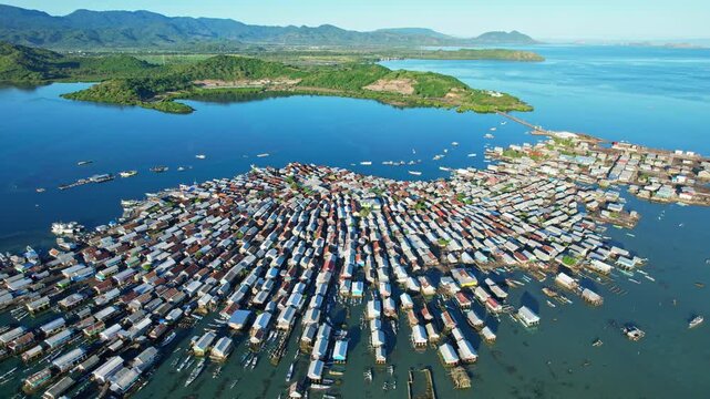 Aerial drone footage of Bungin most congested island in the world at sunrise, in blue water bay, and Olet Sangenges moutain area in the back, in Sumbawa island, Indonesia