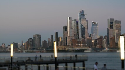 Obraz premium New York City Manhattan Midtown skyline, Chelsea and Hudson Yards towers from New Jersey, Hoboken pier, United States. River waterfront urban cityscape with skyscraper buildings, Evening dusk twilight