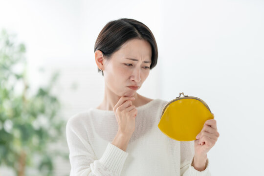 財布を持って悩む女性