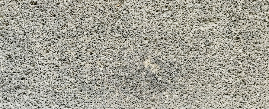 Grey porous volcanic stone texture background with rough basalt surface