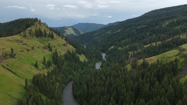 Aerial over Minam River in spring with green hillsides along Oregon Highway 82
