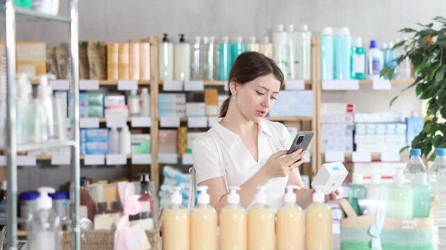 Beautiful young woman scans boxes of pills on her mobile barcode. Buyer pays for purchases using an online application and a QR code. High quality 4k footage