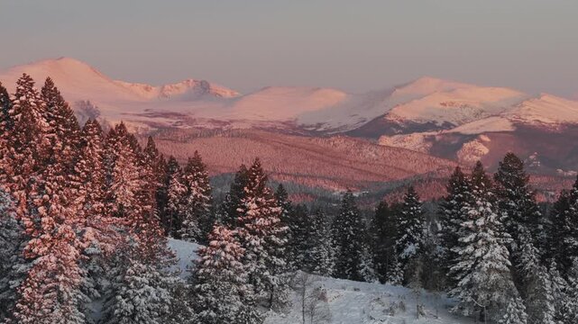 First light sunrise purple Rocky Mountains majesty Mount Blue Sky Evergreen Colorado aerial drone springtime fresh snow vibrant alpenglow early morning Mt Evans wilderness landscape parallax zoom in