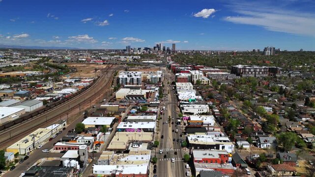 Downtown City of Denver S Broadway cityscape landscape spring summer sunny morning Burnham Yard railyard aerial drone Colorado i25 cars traffic city i25 highway buildings Front Range forward motion