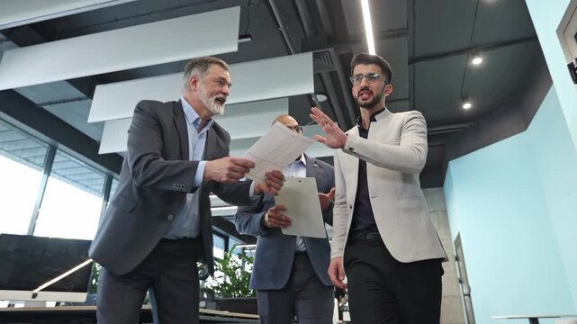 Two men in business attire stand in an open office space