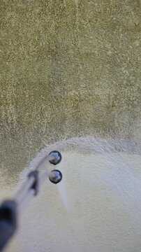 Professional exterior home maintenance, cleaning a stained wall with
